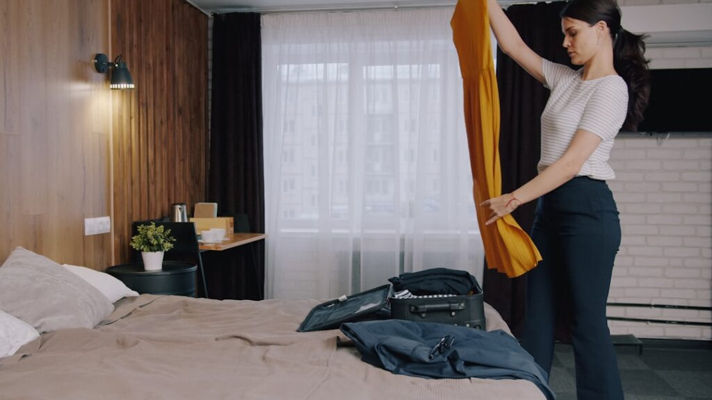 Traveller packing clothing into a carry on suitcase for a one week trip